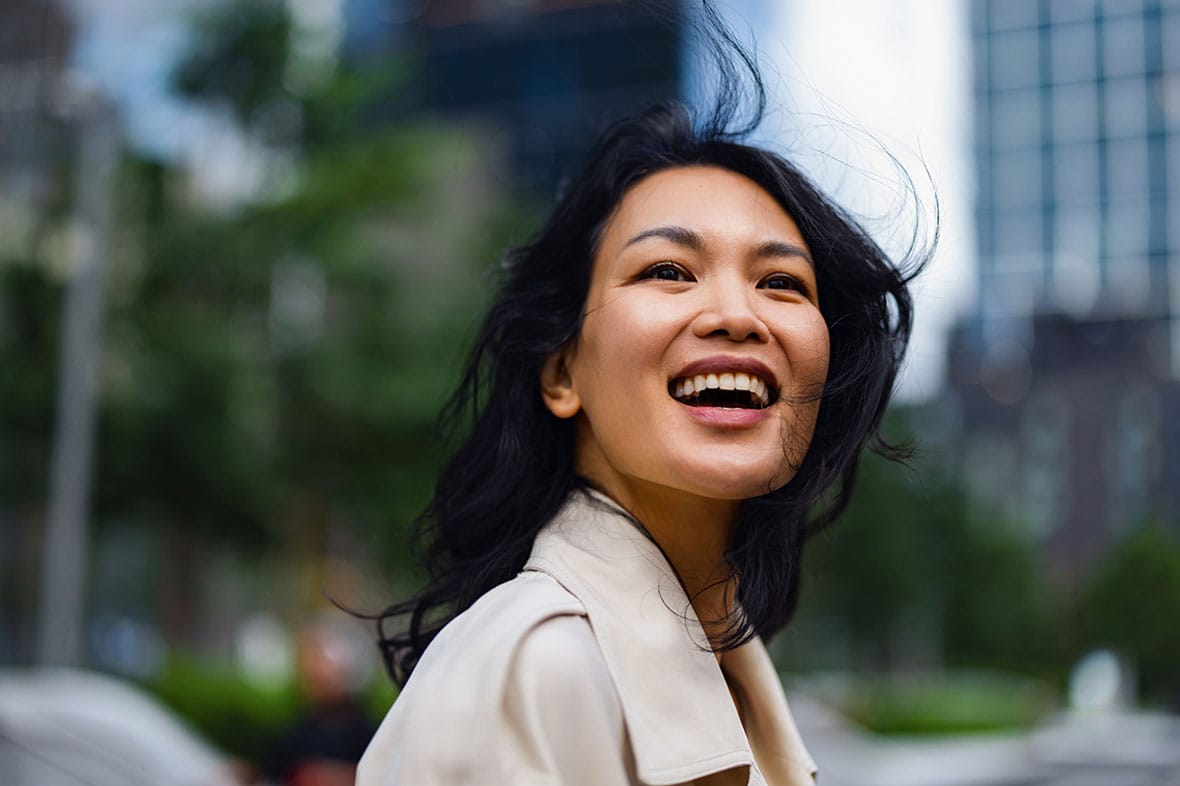 woman smiling and walking around NYC after her facelift